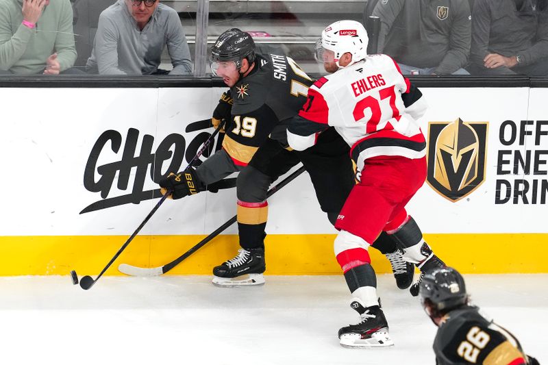 Oct 20, 2025; Las Vegas, Nevada, USA; Vegas Golden Knights right wing Reilly Smith (19) clears the puck away from Carolina Hurricanes left wing Nikolaj Ehlers (27) during the second period at T-Mobile Arena. Mandatory Credit: Stephen R. Sylvanie-Imagn Images