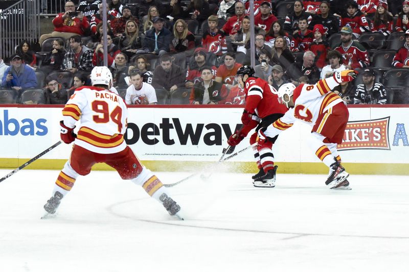 Feb 8, 2024; Newark, New Jersey, USA; New Jersey Devils center Curtis Lazar (42) skates with the puck while being defended by Calgary Flames center Nazem Kadri (91) and Calgary Flames defenseman Brayden Pachal (94) during the second period at Prudential Center. Mandatory Credit: John Jones-USA TODAY Sports