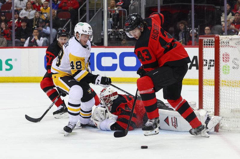 Mar 19, 2024; Newark, New Jersey, USA; New Jersey Devils defenseman Luke Hughes (43) takes the puck away from Pittsburgh Penguins right wing Valtteri Puustinen (48) during the first period at Prudential Center. Mandatory Credit: Ed Mulholland-USA TODAY Sports