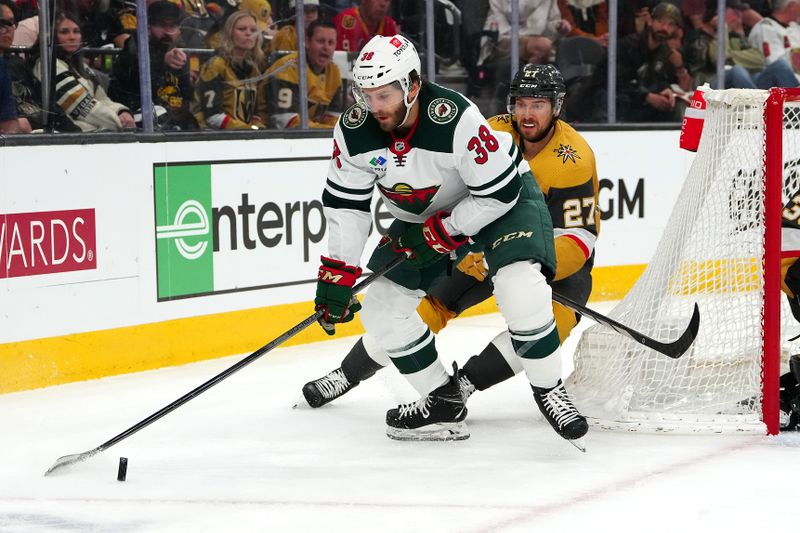 Apr 12, 2024; Las Vegas, Nevada, USA; Minnesota Wild right wing Ryan Hartman (38) controls the puck ahead of Vegas Golden Knights defenseman Shea Theodore (27) during the first period at T-Mobile Arena. Mandatory Credit: Stephen R. Sylvanie-USA TODAY Sports