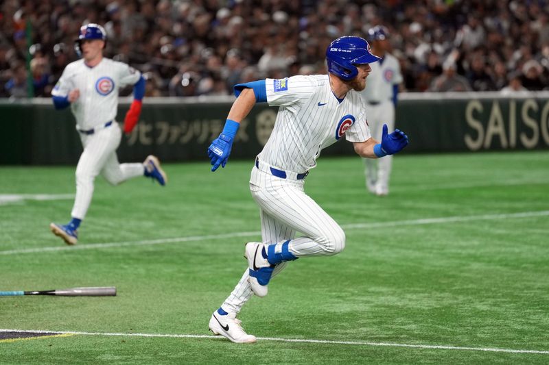 Mar 16, 2025; Bunkyo, Tokyo, Japan; Chicago Cubs second baseman Gage Workman (center) runs to first base after hitting an RBI-single against the Yomiuri Giants to score center fielder Pete Crow-Armstrong (background left) during the fifth inning at Tokyo Dome. Mandatory Credit: Darren Yamashita-Imagn Images