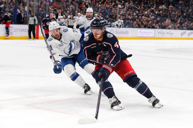 Nov 21, 2024; Columbus, Ohio, USA; Columbus Blue Jackets center Cole Sillinger (4) carries the puck around the check of Tampa Bay Lightning center Anthony Cirelli (71) during overtime at Nationwide Arena. Mandatory Credit: Russell LaBounty-Imagn Images