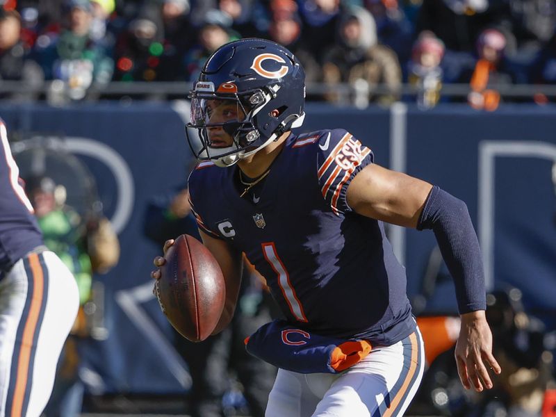 Chicago Bears quarterback Justin Fields (1) rushes with the ball during the first half of an NFL football game against the Philadelphia Eagles, Sunday, Dec. 18, 2022, in Chicago. (AP Photo/Kamil Krzaczynski)