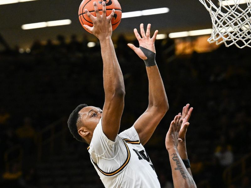 Jan 20, 2026; Iowa City, Iowa, USA; Iowa Hawkeyes forward Cam Manyawu (3) goes to the basket as Rutgers Scarlet Knights guard Darren Buchanan Jr. (5) and center Emmanuel Ogbole (21) defend during the 2nd half at Carver-Hawkeye Arena. Mandatory Credit: Jeffrey Becker-Imagn Images