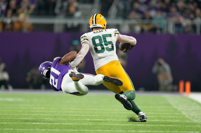 Minnesota Vikings' Akayleb Evans tries to stop Green Bay Packers' Tucker Kraft after a catch during the first half of an NFL football game Sunday, Dec. 31, 2023, in Minneapolis. (AP Photo/Abbie Parr)