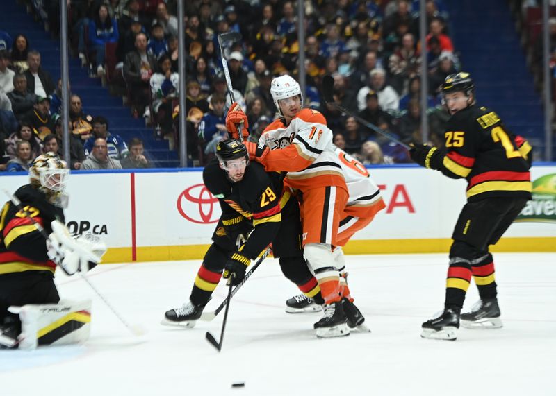 Mar 5, 2025; Vancouver, British Columbia, CAN;  Vancouver Canucks defenseman Marcus Pettersson (29) defends against Anaheim Ducks forward Troy Terry (19) during the third period at Rogers Arena. Mandatory Credit: Simon Fearn-Imagn Images