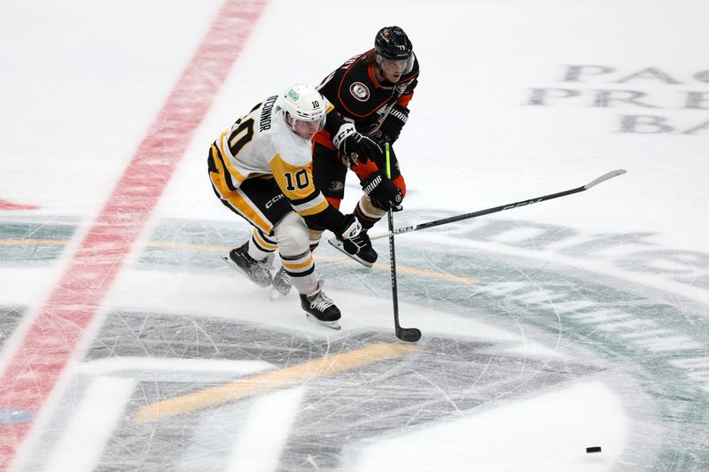 Nov 7, 2023; Anaheim, California, USA; Anaheim Ducks right wing Troy Terry (19) fights for the puck against Pittsburgh Penguins left wing Drew O'Connor (10) during the third period at Honda Center. Mandatory Credit: Kiyoshi Mio-USA TODAY Sports