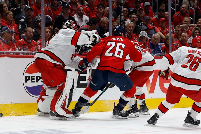May 6, 2025; Washington, District of Columbia, USA; Carolina Hurricanes goaltender Frederik Andersen (31), Washington Capitals center Nic Dowd (26), and Hurricanes defenseman Shayne Gostisbehere (4) battle for the puck in the first period in game one of the second round of the 2025 Stanley Cup Playoffs at Capital One Arena. Mandatory Credit: Geoff Burke-Imagn Images