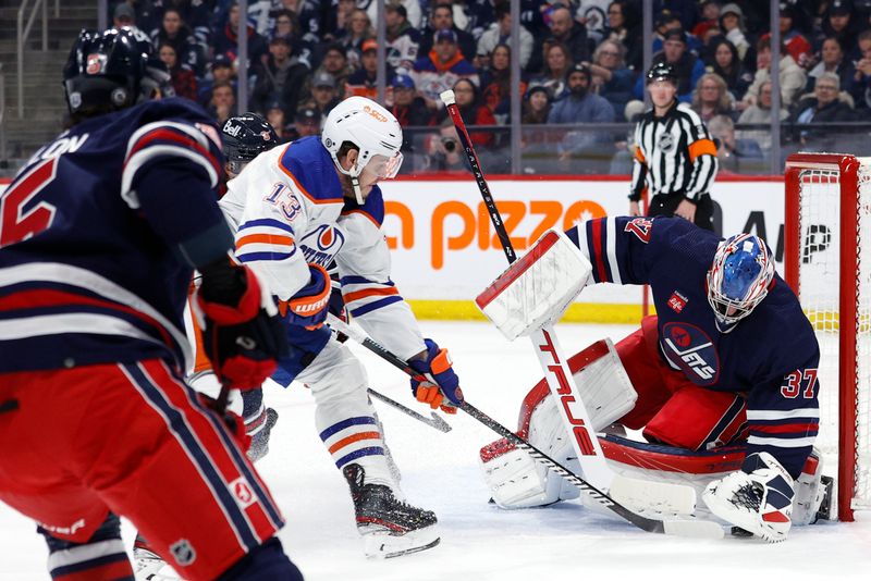 Mar 26, 2024; Winnipeg, Manitoba, CAN; Winnipeg Jets goaltender Connor Hellebuyck (37) covers up a rebound from Edmonton Oilers center Mattias Janmark (13) in the first period at Canada Life Centre. Mandatory Credit: James Carey Lauder-USA TODAY Sports