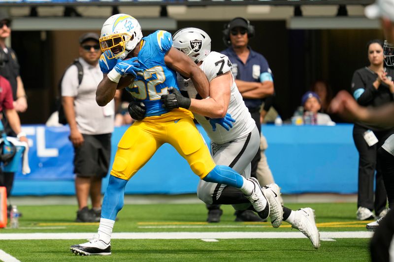 Los Angeles Chargers linebacker Khalil Mack (52) returns a fumble against Las Vegas Raiders offensive tackle Kolton Miller during the first half of an NFL football game, Sunday, Sept. 8, 2024, in Inglewood, Calif. (AP Photo/Ashley Landis)