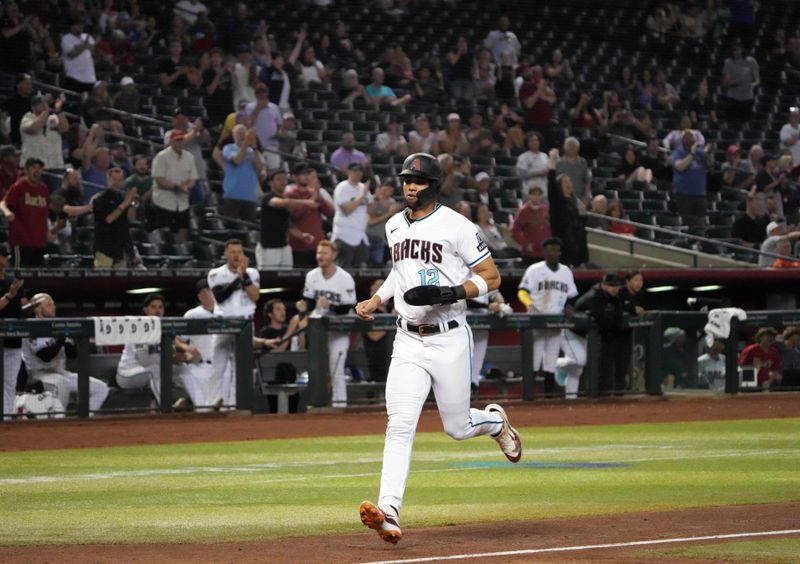 Apr 25, 2023; Phoenix, Arizona, USA; Arizona Diamondbacks left fielder Lourdes Gurriel Jr. (12) scores a run against the Kansas City Royals during the eighth inning at Chase Field. Mandatory Credit: Joe Camporeale-USA TODAY Sports