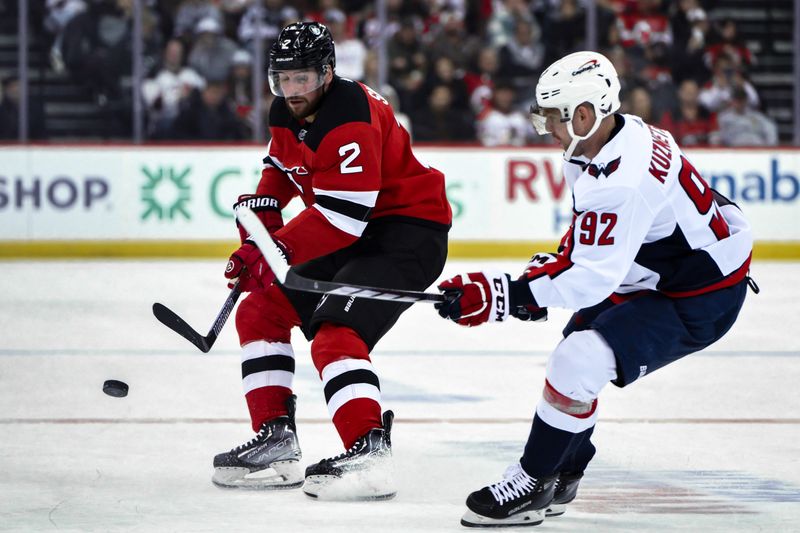 Nov 10, 2023; Newark, New Jersey, USA; New Jersey Devils defenseman Brendan Smith (2) passes the puck against Washington Capitals center Evgeny Kuznetsov (92) during the second period at Prudential Center. Mandatory Credit: John Jones-USA TODAY Sports