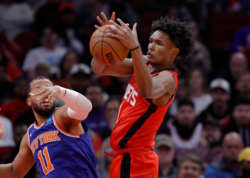 HOUSTON, TEXAS - FEBRUARY 12: Amen Thompson #1 of the Houston Rockets grabs a rebound ahead of Jalen Brunson #11 of the New York Knicks during the first half at Toyota Center on February 12, 2024 in Houston, Texas. NOTE TO USER: User expressly acknowledges and agrees that, by downloading and or using this photograph, User is consenting to the terms and conditions of the Getty Images License Agreement. (Photo by Carmen Mandato/Getty Images)