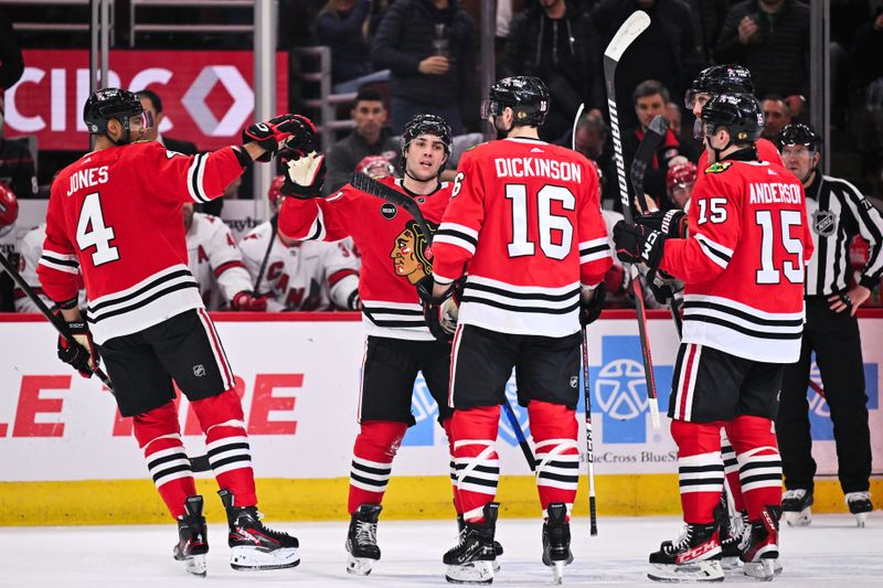 Apr 14, 2024; Chicago, Illinois, USA; Chicago Blackhawks forward Frank Nazar (91) celebrates with teammates defenseman Seth Jones (4), forward Jason Dickinson (16) and forward Joey Anderson (15) after scoring his first NHL goal in his NHL debut in the first period against the Carolina Hurricanes at United Center. Mandatory Credit: Jamie Sabau-USA TODAY Sports