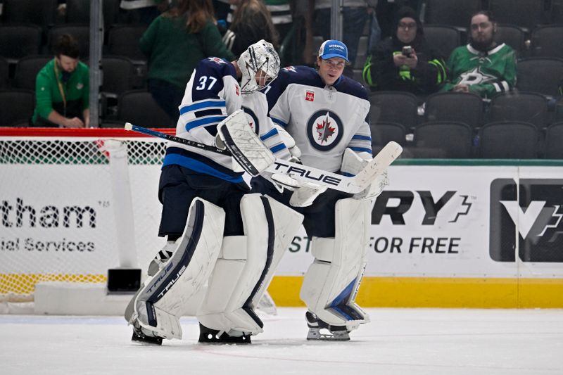 Apr 10, 2025; Dallas, Texas, USA; Winnipeg Jets goaltender Connor Hellebuyck (37) and goaltender Eric Comrie (1) celebrate on the ice after Hellebuyck gets the shutout win over the Dallas Stars at the American Airlines Center. Mandatory Credit: Jerome Miron-Imagn Images
