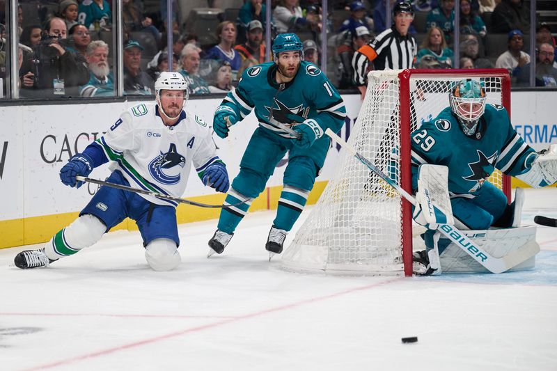 Nov 2, 2024; San Jose, California, USA; Vancouver Canucks center J.T. Miller (9) watches the puck against San Jose Sharks center Luke Kunin (11) and goaltender Mackenzie Blackwood (29) during the first period at SAP Center at San Jose. Mandatory Credit: Robert Edwards-Imagn Images