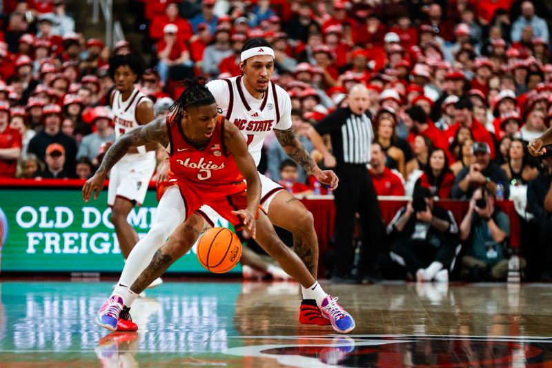 Feb 7, 2026; Raleigh, North Carolina, USA; Virginia Tech Hokies guard Ben Hammond (3) dribbles with the ball guarded by NC State Wolfpack forward Darrion Williams (1) during the first half of the game at Lenovo Center. Mandatory Credit: Jaylynn Nash-Imagn Images