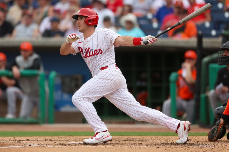 Mar 5, 2024; Clearwater, Florida, USA;  Philadelphia Phillies catcher J.T. Realmuto (10) doubles against the Baltimore Orioles in the fourth inning at BayCare Ballpark. Mandatory Credit: Nathan Ray Seebeck-USA TODAY Sports