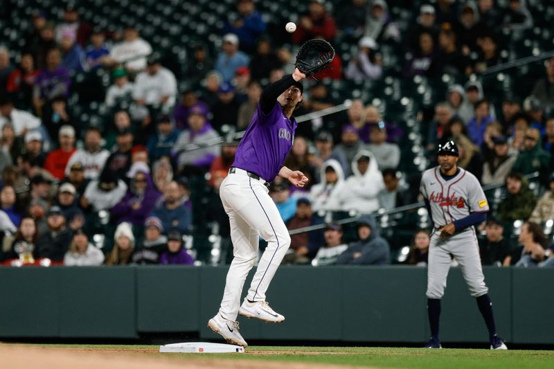 Apr 28, 2025; Denver, Colorado, USA; Colorado Rockies first baseman Michael Toglia (4) fields a throw in the seventh inning against the Atlanta Braves at Coors Field. Mandatory Credit: Isaiah J. Downing-Imagn Images