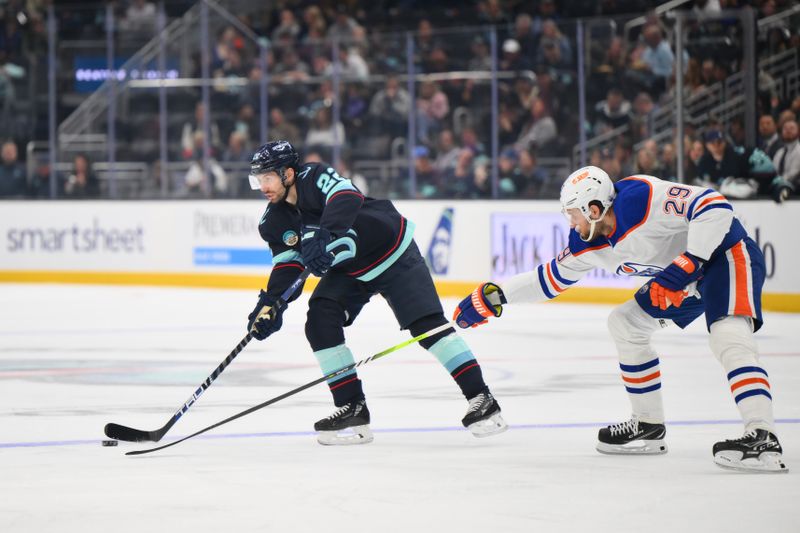 Oct 2, 2024; Seattle, Washington, USA; Seattle Kraken right wing Oliver Bjorkstrand (22) advances the puck while defended by Edmonton Oilers center Leon Draisaitl (29) during the first period at Climate Pledge Arena. Mandatory Credit: Steven Bisig-Imagn Images