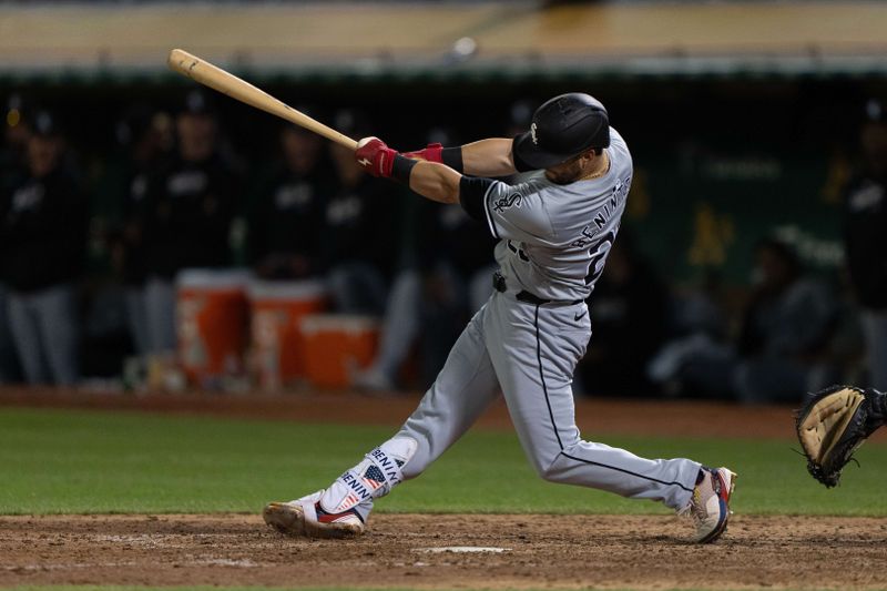 Aug 6, 2024; Oakland, California, USA;  Chicago White Sox outfielder Andrew Benintendi (23) hits a double during the ninth inning against the Oakland Athletics at Oakland-Alameda County Coliseum. Mandatory Credit: Stan Szeto-USA TODAY Sports