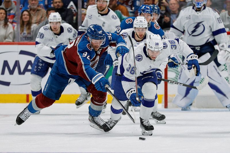 Nov 4, 2025; Denver, Colorado, USA; Tampa Bay Lightning left wing Brandon Hagel (38) and Colorado Avalanche left wing Gabriel Landeskog (92) battle for the puck in the third period at Ball Arena. Mandatory Credit: Isaiah J. Downing-Imagn Images
