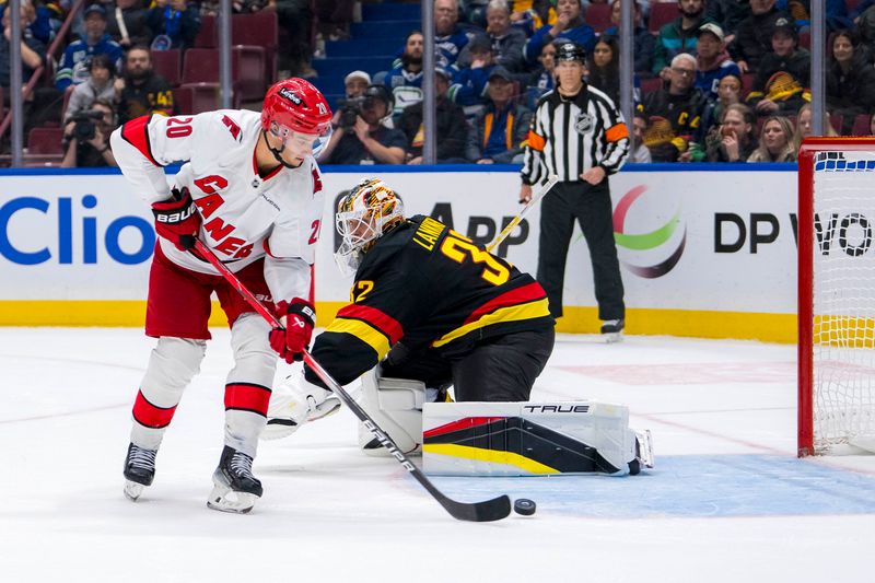 Oct 28, 2024; Vancouver, British Columbia, CAN; Carolina Hurricanes forward Sebastian Aho (20) scores the game winning goal on Vancouver Canucks goalie Kevin Lankinen (32) in overtime at Rogers Arena. Mandatory Credit: Bob Frid-Imagn Images