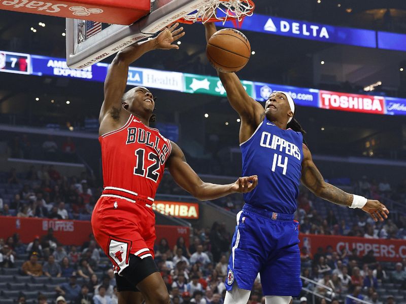 LOS ANGELES, CALIFORNIA - MARCH 09:  Ayo Dosunmu #12 of the Chicago Bulls makes a slam dunk against Terance Mann #14 of the LA Clippers in the first half at Crypto.com Arena on March 09, 2024 in Los Angeles, California.  NOTE TO USER: User expressly acknowledges and agrees that, by downloading and/or using this photograph, user is consenting to the terms and conditions of the Getty Images License Agreement.  (Photo by Ronald Martinez/Getty Images)