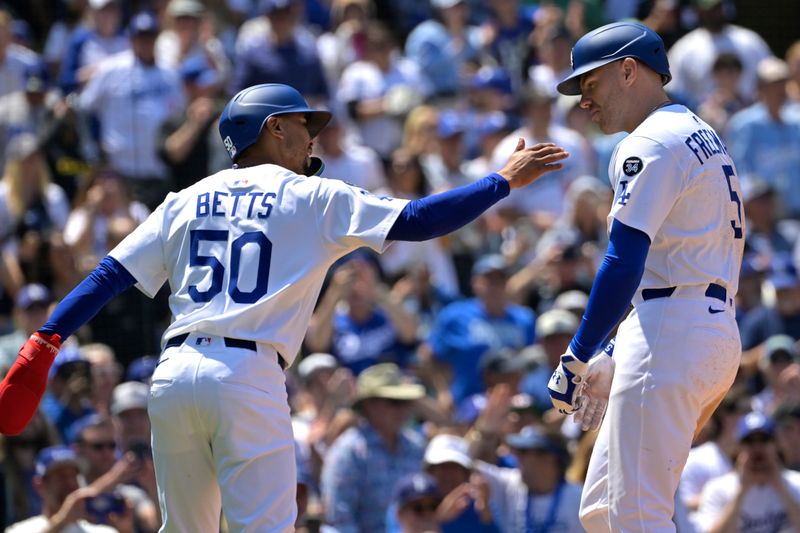 Apr 30, 2025; Los Angeles, California, USA;  Los Angeles Dodgers first baseman Freddie Freeman (5) is greeted by shortstop Mookie Betts (50) at the plate after a two run home run in the sixth inning at Dodger Stadium. Mandatory Credit: Jayne Kamin-Oncea-Imagn Images