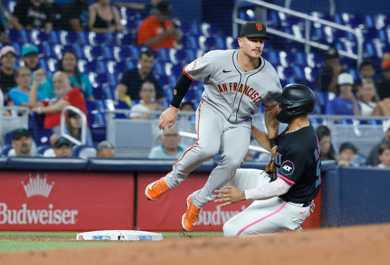 May 31, 2025; Miami, Florida, USA;  Miami Marlins catcher Agustin Ramirez (50) is tagged out by San Francisco Giants third baseman Matt Chapman (26) as he tries to steal third base during the first inning at loanDepot Park. Mandatory Credit: Rhona Wise-Imagn Images