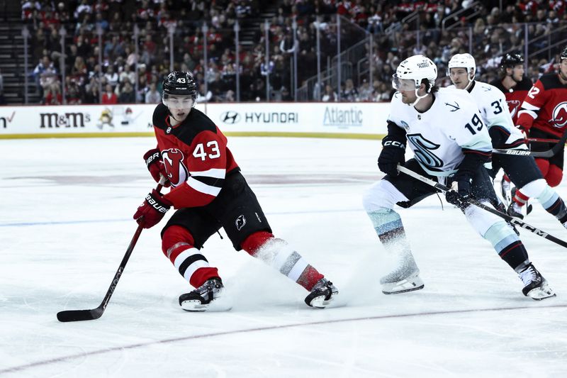 Feb 12, 2024; Newark, New Jersey, USA; New Jersey Devils defenseman Luke Hughes (43) third-period goal Seattle Kraken left wing Jared McCann (19) during the second period at Prudential Center. Mandatory Credit: John Jones-USA TODAY Sports