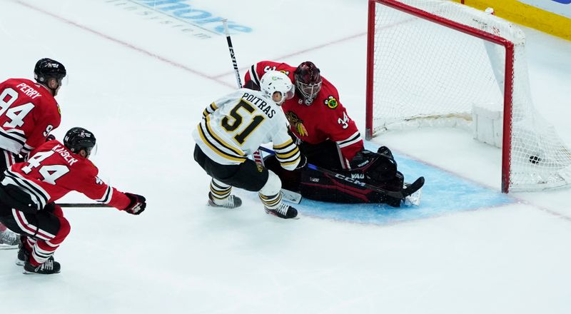 Oct 24, 2023; Chicago, Illinois, USA; Boston Bruins center Matthew Poitras (51) scores a goal on Chicago Blackhawks goaltender Petr Mrazek (34) during the third period at United Center. Mandatory Credit: David Banks-USA TODAY Sports