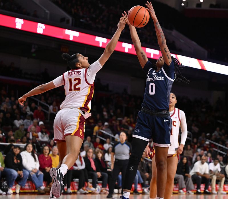 Jan 12, 2025; Los Angeles, California, USA; USC Trojans guard JuJu Watkins (12) blocks a shot by Penn State Nittany Lions guard Gabby Elliott (0) during the first quarter  at Galen Center. Mandatory Credit: Robert Hanashiro-Imagn Images