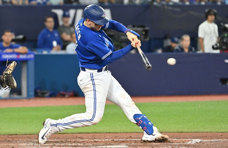 Aug 26, 2023; Toronto, Ontario, CAN;  Toronto Blue Jays catcher Danny Jansen (9) hits a double against the Cleveland Guardians in the fourth inning at Rogers Centre. Mandatory Credit: Dan Hamilton-USA TODAY Sports