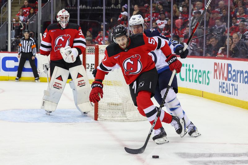 Mar 21, 2024; Newark, New Jersey, USA; New Jersey Devils defenseman Nick DeSimone (57) skates with the puck against the Winnipeg Jets during the first period at Prudential Center. Mandatory Credit: Ed Mulholland-USA TODAY Sports