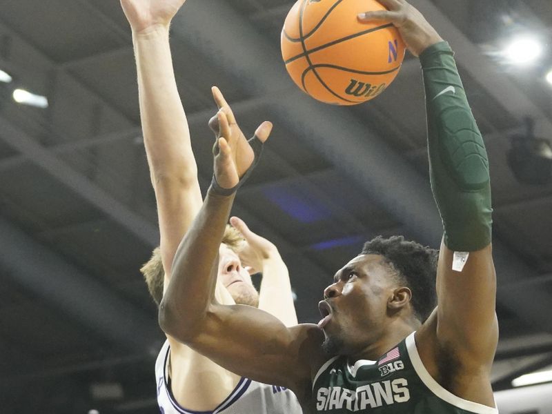 Jan 7, 2024; Evanston, Illinois, USA; Northwestern Wildcats forward Luke Hunger (33) defends Michigan State Spartans center Mady Sissoko (22) during the first half at Welsh-Ryan Arena. Mandatory Credit: David Banks-USA TODAY Sports