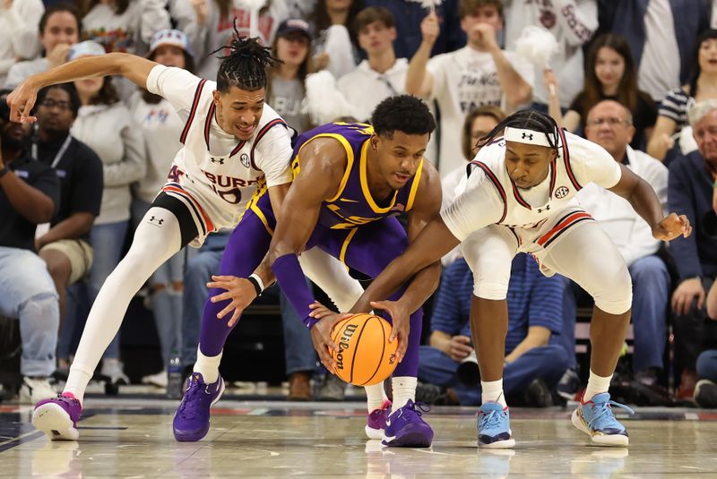 Jan 13, 2024; Auburn, Alabama, USA; Auburn Tigers guards Chad Baker-Mazara (10) and  Denver Jones (12) fight for the ball with LSU Tigers guard Jordan Wright (6) during the second half at Neville Arena. Mandatory Credit: John Reed-USA TODAY Sports