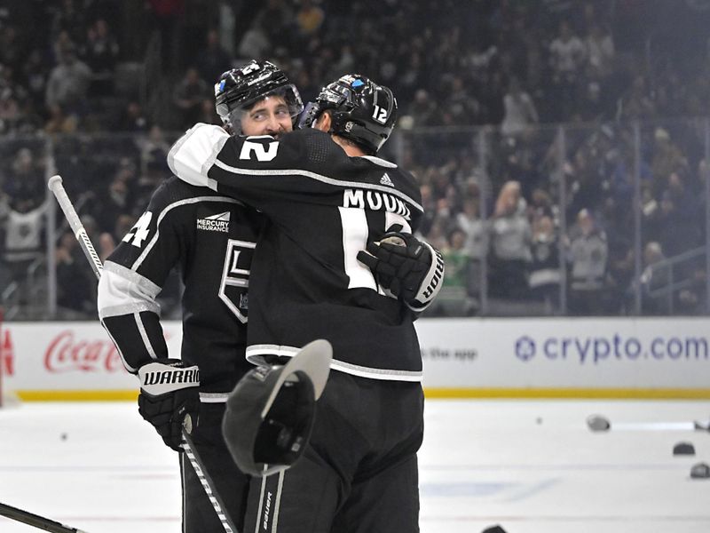 Mar 3, 2024; Los Angeles, California, USA; Hats litter the ice as Los Angeles Kings center Phillip Danault (24) is congratulated by Los Angeles Kings left wing Trevor Moore (12) after scoring a hat trick in the third period against the New Jersey Devils at Crypto.com Arena. Mandatory Credit: Jayne Kamin-Oncea-USA TODAY Sports