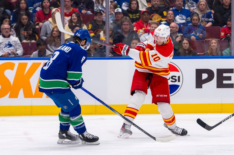 Apr 16, 2024; Vancouver, British Columbia, CAN; Calgary Flames forward Jonathan Huberdeau (10) shoots around Vancouver Canucks forward Conor Garland (8) in the second period at Rogers Arena. Mandatory Credit: Bob Frid-USA TODAY Sports