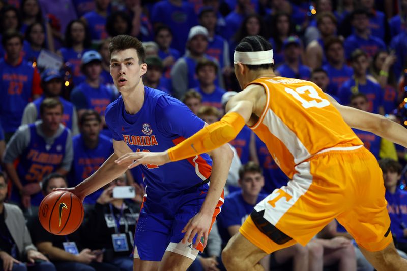 Feb 1, 2023; Gainesville, Florida, USA; Florida Gators forward Colin Castleton (12) drives to the basket as Tennessee Volunteers forward Olivier Nkamhoua (13) defends during the first half at Exactech Arena at the Stephen C. O'Connell Center. Mandatory Credit: Kim Klement-USA TODAY Sports