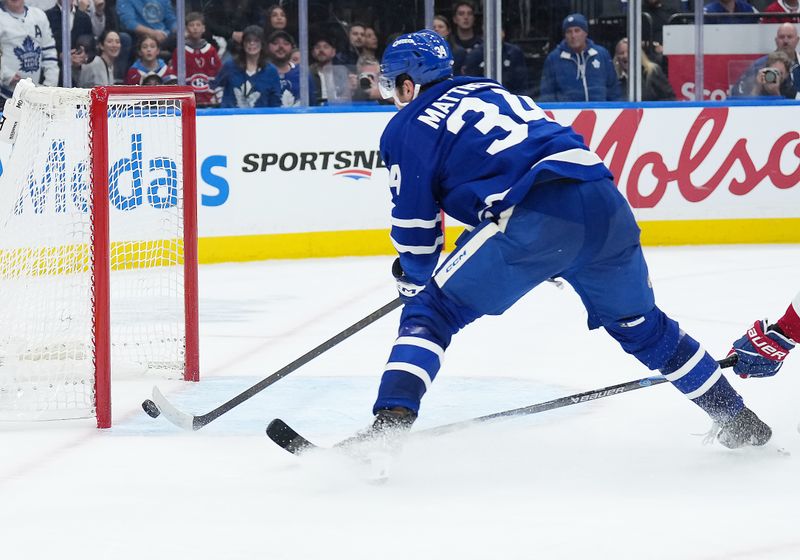 Oct 8, 2025; Toronto, Ontario, CAN; Toronto Maple Leafs center Auston Matthews (34) scores an empty net goal against the Montreal Canadiens during the third period at Scotiabank Arena. Mandatory Credit: Nick Turchiaro-Imagn Images