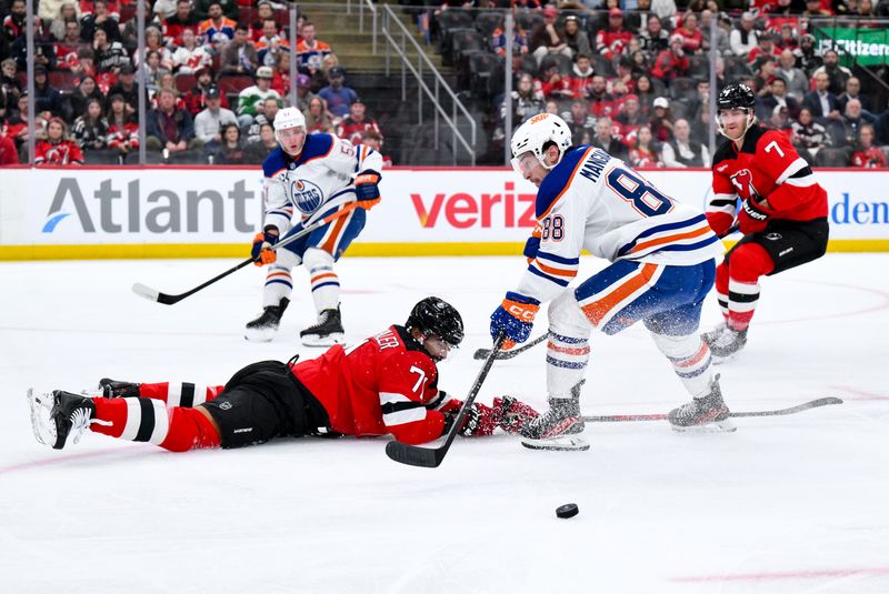 Oct 18, 2025; Newark, New Jersey, USA; Edmonton Oilers left wing Andrew Mangiapane (88) tries to skate past New Jersey Devils defenseman Jonas Siegenthaler (71) during the first period at Prudential Center. Mandatory Credit: John Jones-Imagn Images