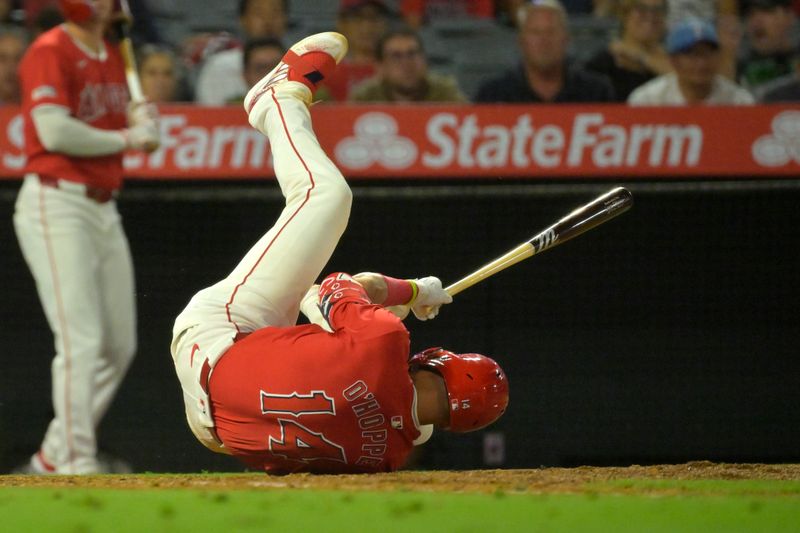 Jul 9, 2024; Anaheim, California, USA; Los Angeles Angels catcher Logan O'Hoppe (14) lands on the dirt after backing off an inside pitch in the ninth inning against the Texas Rangers at Angel Stadium. Mandatory Credit: Jayne Kamin-Oncea-USA TODAY Sports