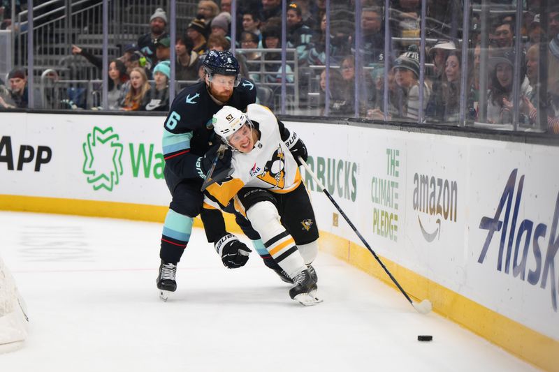 Jan 25, 2025; Seattle, Washington, USA; Seattle Kraken defenseman Adam Larsson (6) and Pittsburgh Penguins right wing Rickard Rakell (67) chase a loose puck during the second period at Climate Pledge Arena. Mandatory Credit: Steven Bisig-Imagn Images