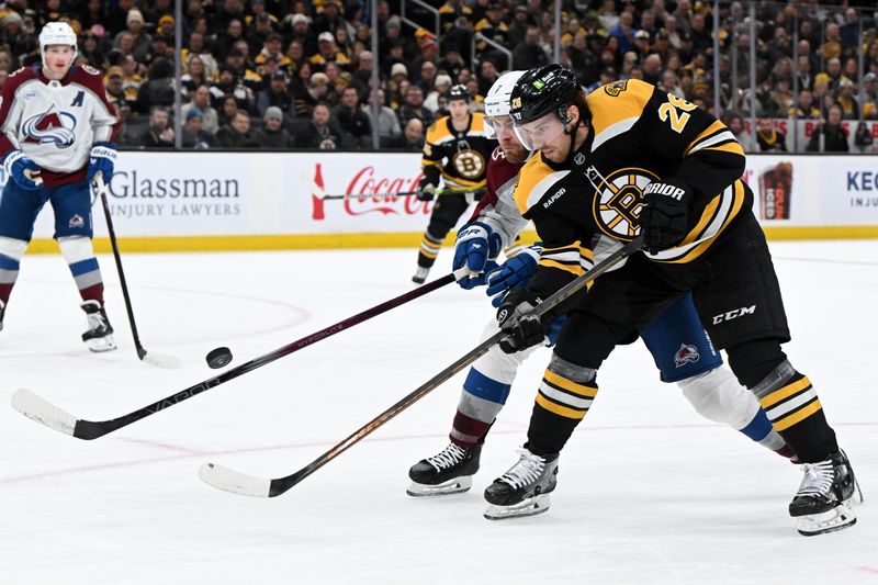 Jan 25, 2025; Boston, Massachusetts, USA; Boston Bruins center Elias Lindholm (28) and Colorado Avalanche defenseman Devon Toews (7) battle for the puck during the first period at the TD Garden. Mandatory Credit: Brian Fluharty-Imagn Images