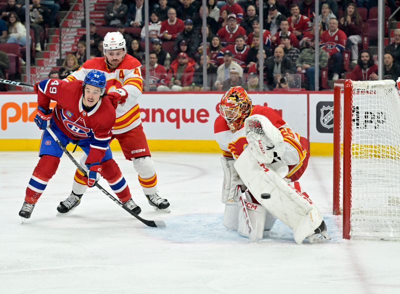 Nov 14, 2023; Montreal, Quebec, CAN; Calgary Flames goalie Jacob Markstrom (25) stops Montreal Canadiens forward Rafael Harvey-Pinard (49) during the first period at the Bell Centre. Mandatory Credit: Eric Bolte-USA TODAY Sports