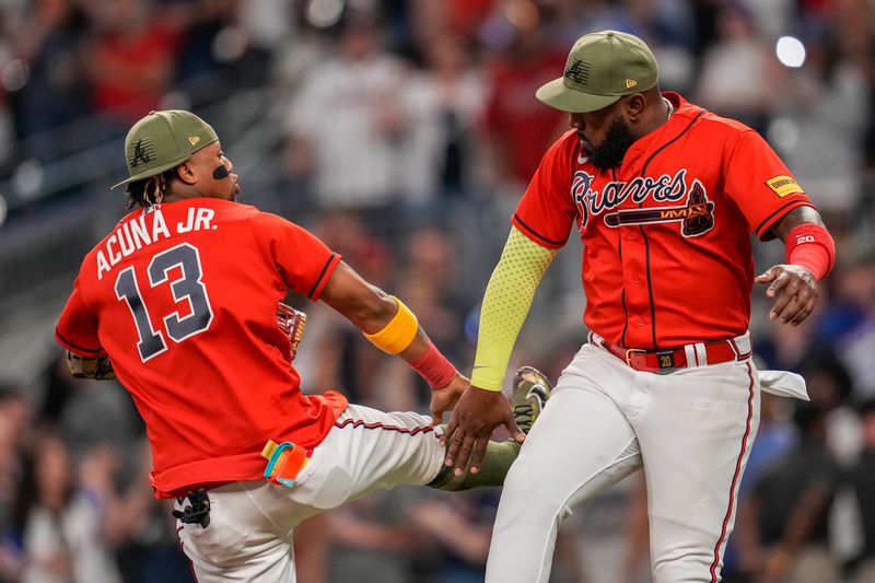 May 19, 2023; Cumberland, Georgia, USA; Atlanta Braves right fielder Ronald Acuna Jr. (13) and designated hitter Marcell Ozuna (20) react after defeating the Seattle Mariners at Truist Park. Mandatory Credit: Dale Zanine-USA TODAY Sports