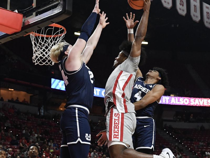 Jan 13, 2024; Las Vegas, Nevada, USA; UNLV Rebels forward Rob Whaley Jr. (5) tries to score on Utah State Aggies forward Karson Templin (24) and guard Ian Martinez (4) in the first half at Thomas & Mack Center. Mandatory Credit: Candice Ward-USA TODAY Sports