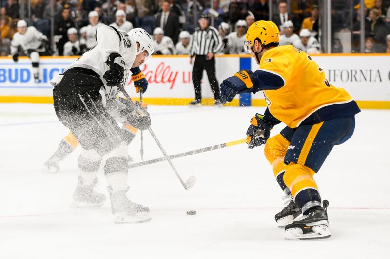 Nov 4, 2024; Nashville, Tennessee, USA;  Nashville Predators defenseman Jeremy Lauzon (3) pokes the puck from Los Angeles Kings left wing Kevin Fiala (22) during the second period at Bridgestone Arena. Mandatory Credit: Steve Roberts-Imagn Images