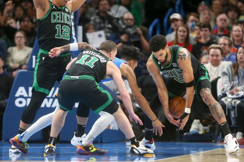 OKLAHOMA CITY, OKLAHOMA - JANUARY 03: Jayson Tatum #0 of the Boston Celtics steals the ball from Tre Mann #23 of the Oklahoma City Thunder while Payton Pritchard #11 of the Boston Celtics defends during the third quarter at Paycom Center on January 03, 2023 in Oklahoma City, Oklahoma. NOTE TO USER: User expressly acknowledges and agrees that, by downloading and or using this photograph, User is consenting to the terms and conditions of the Getty Images License Agreement.  (Photo by Ian Maule/Getty Images)